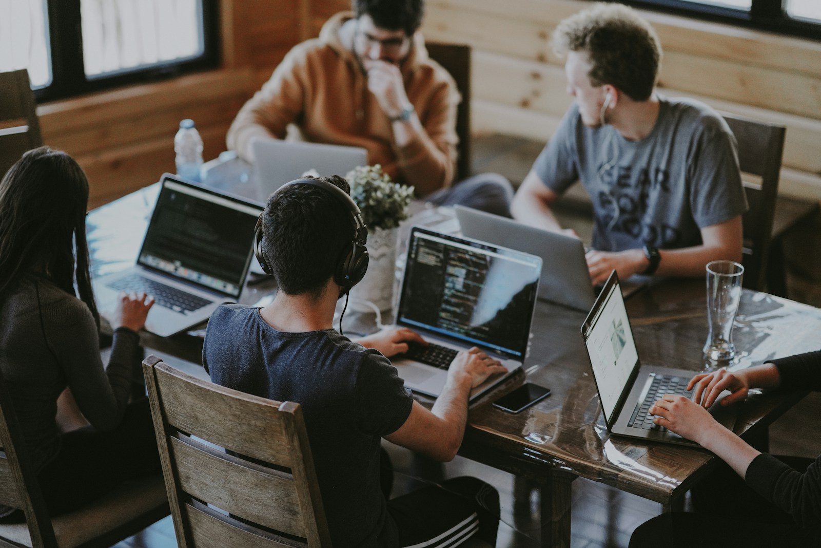People collaborating around laptops at a shared office table